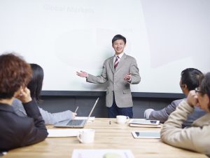 young man conducting presentation in front of  small group of people.