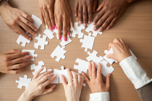 Hands of diverse people assembling - team work -hire intelligence