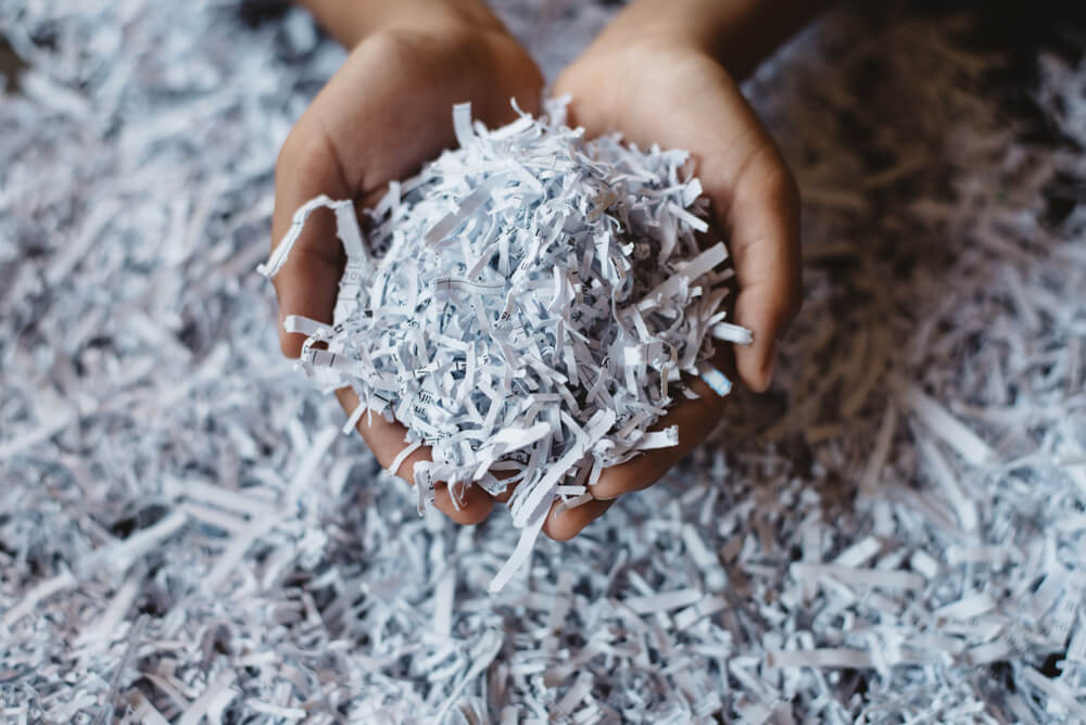 Hand showing heap of shredded paper - hire intelligence au