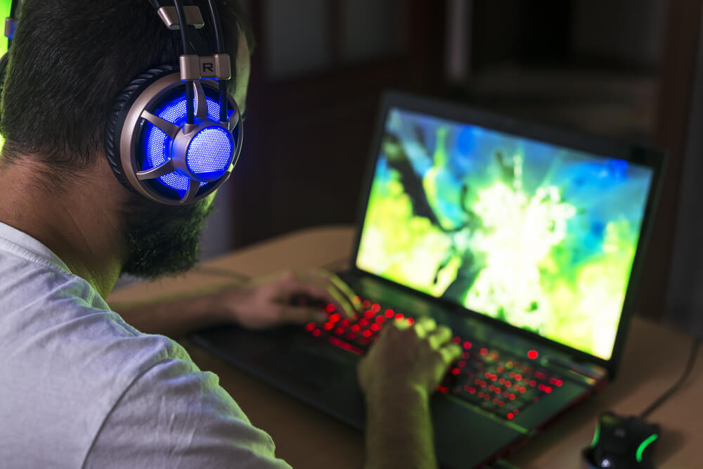 Man using gaming laptop with led keyboard